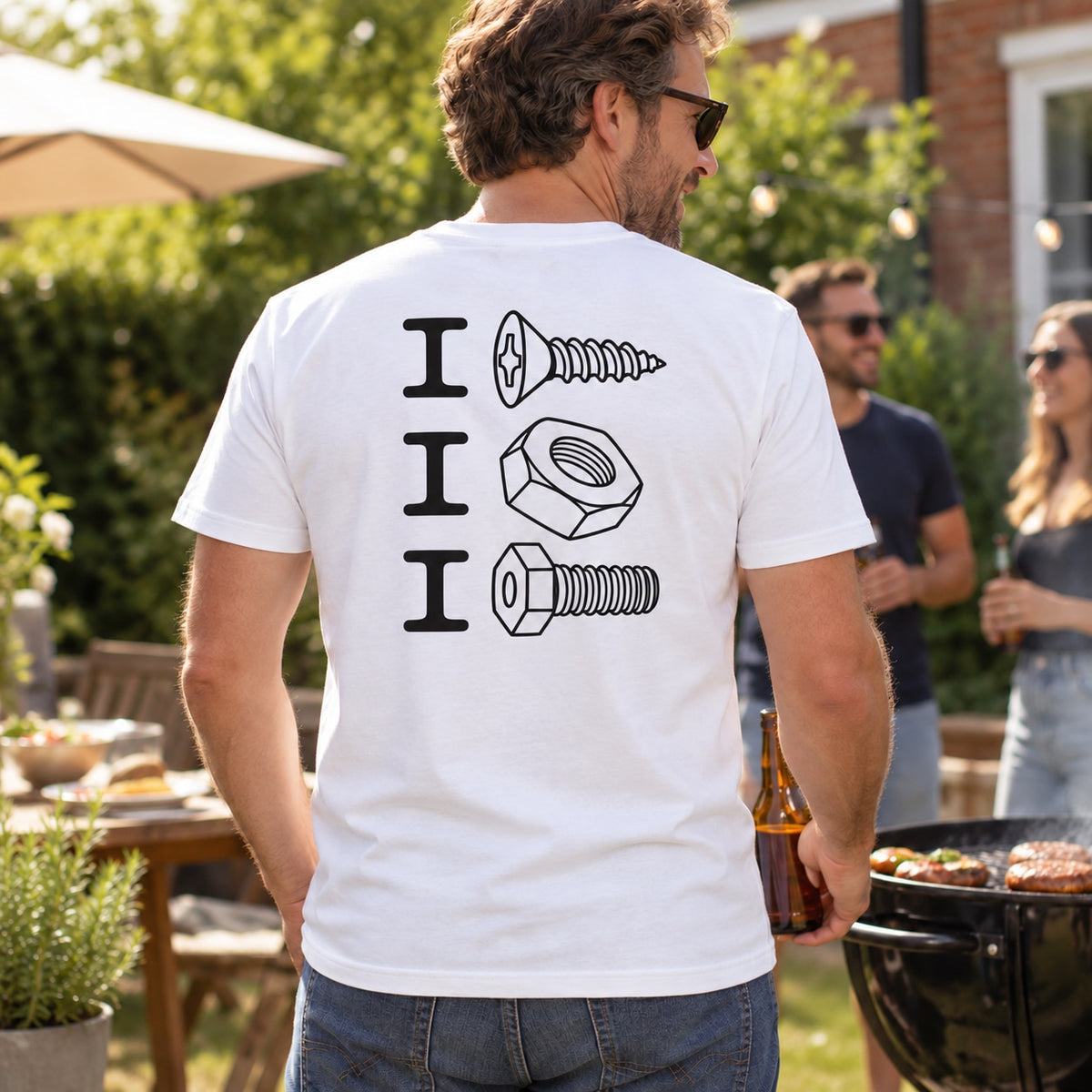Lifestyle mockup of a man wearing the white screw nut bolt back-print T-shirt at a garden BBQ.